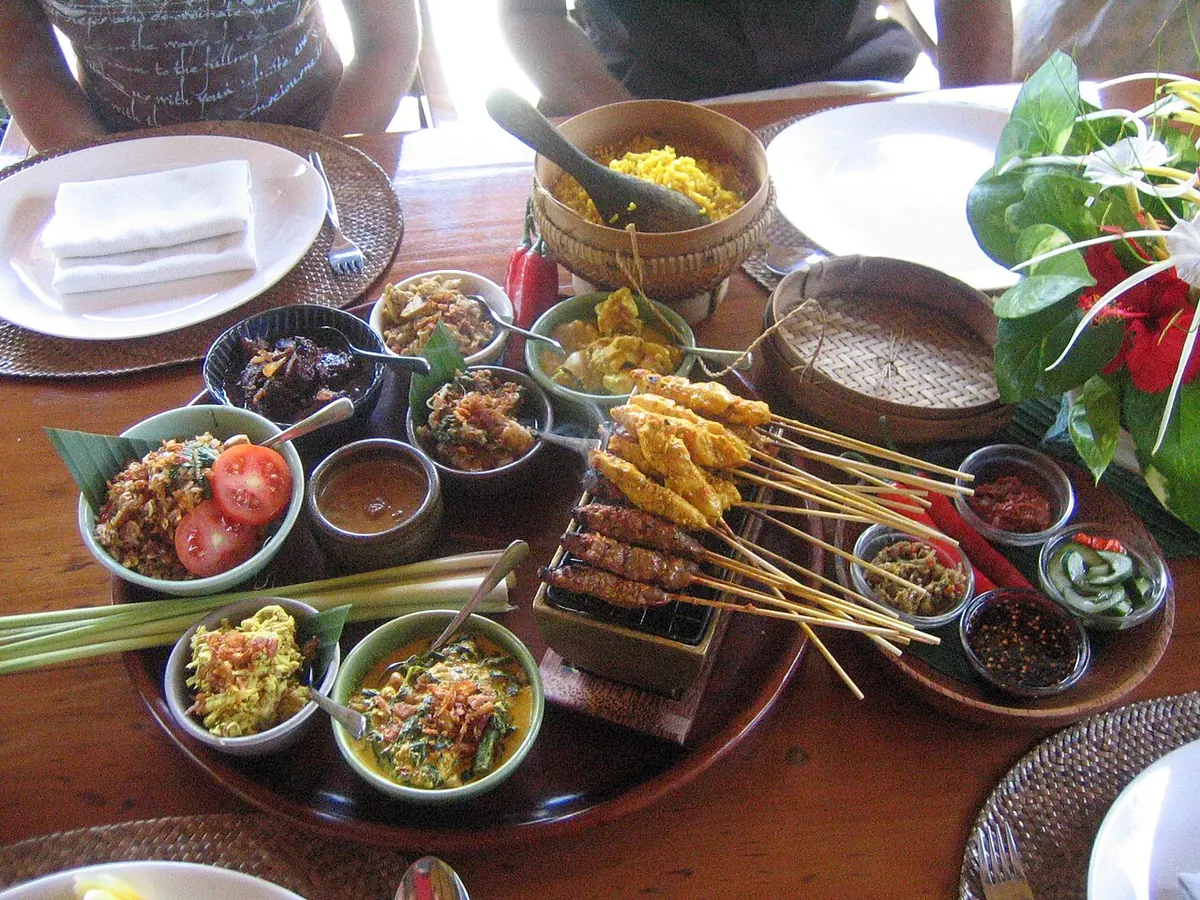 Verschillende Balinese gerechten op een gedekte tafel — Balinese gerechten · sfeerbeeld bij de kookles